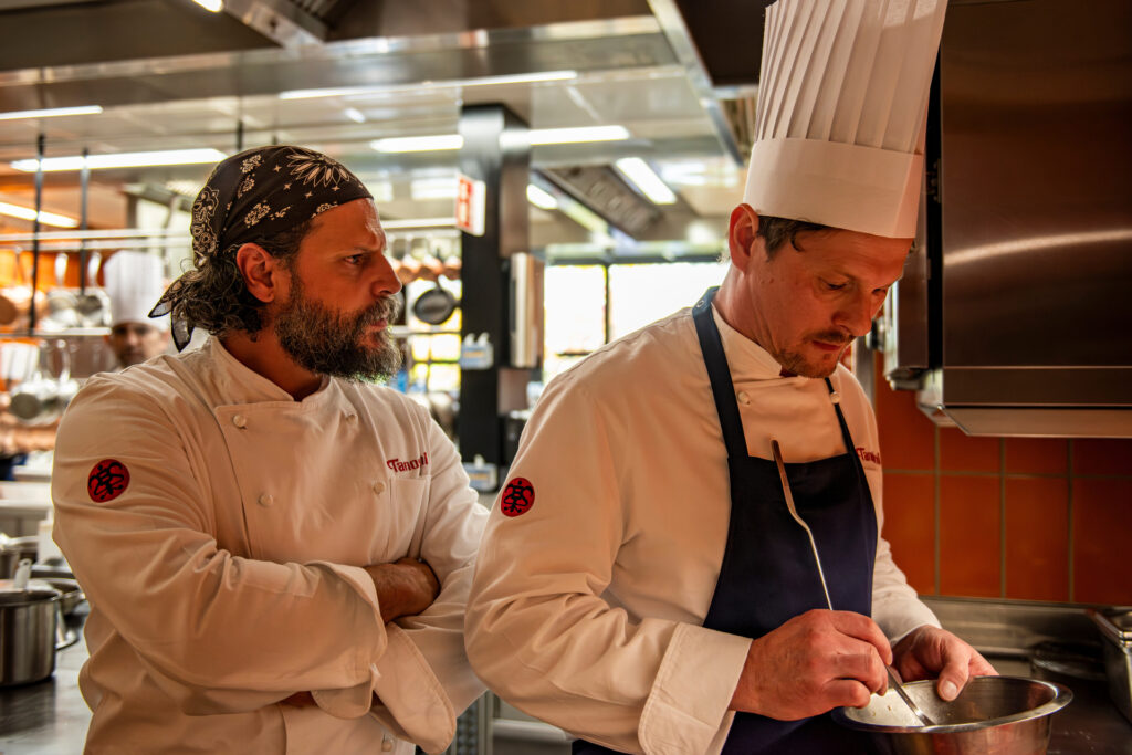 Der Hitzkopf, Chefkoch Maximilian Dobek (Manuel Cortez, l.), ärgert sich über die Beschwerde eines Gastes und weigert sich, zu ihm zu gehen. Sein Kollege Oliver Gerg (Shenja Lacher, r.) bietet an, das zu übernehmen.